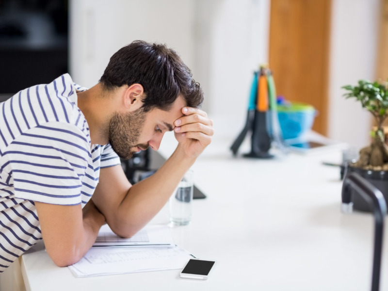 Worried Man Looking At Bills In The Kitchen