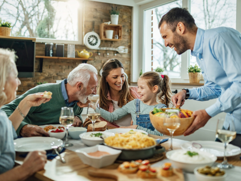 Happy Multi-generation Family Gathering Around Dining Table And Having Fun
